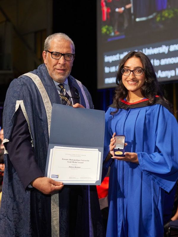 Aanya Kumar (right) and Dr. Mohamed Lachemi, President and Vice-Cancellor of Toronto Metropolitan University (left), posing with the Gold Medal Award and certificate